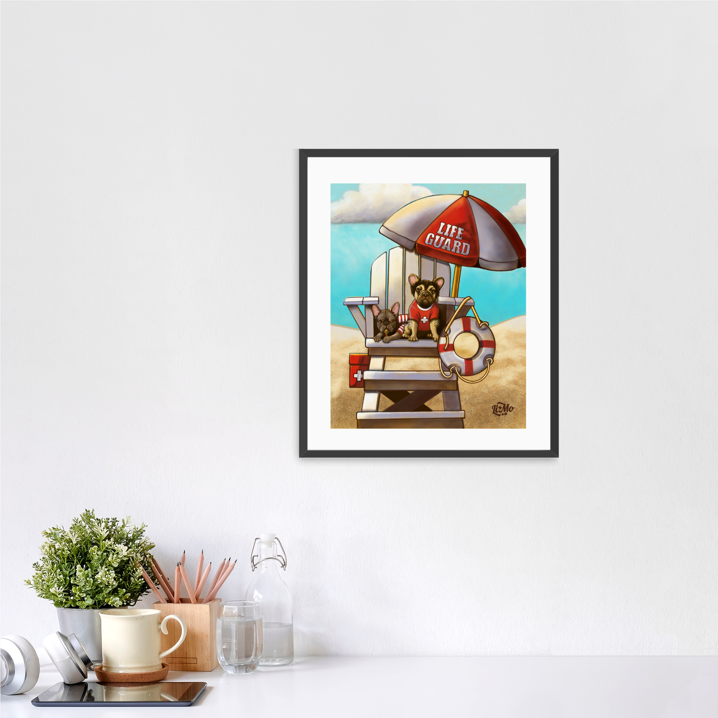 Caution Lifeguards on Duty vertical giclée print, 11x14, in a black frame, 14x17 approximate, on a wall above a white desk.